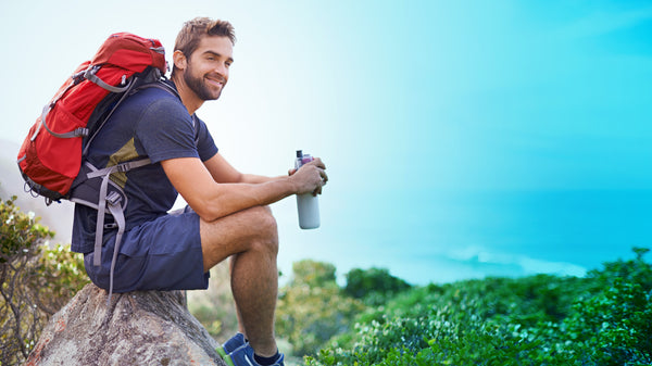 Man taking a break from hiking with water